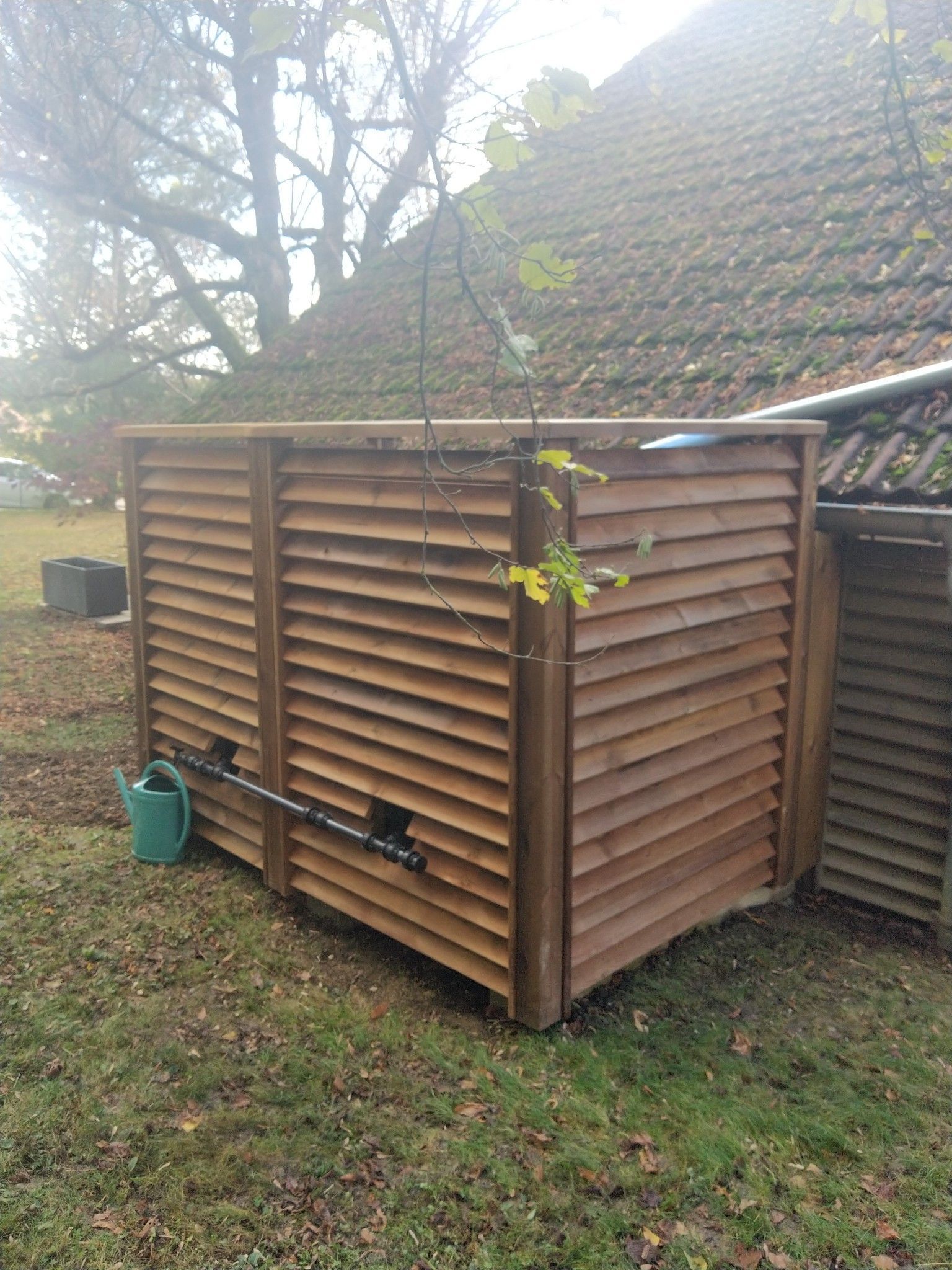 Un récupérateur d'eau de pluie avec un bardage en bois