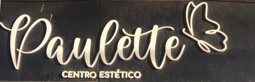 Letrero de salón «Paulette» en letras blancas cursivas, con un icono de mariposa y «Centro Estético» sobre un fondo oscuro