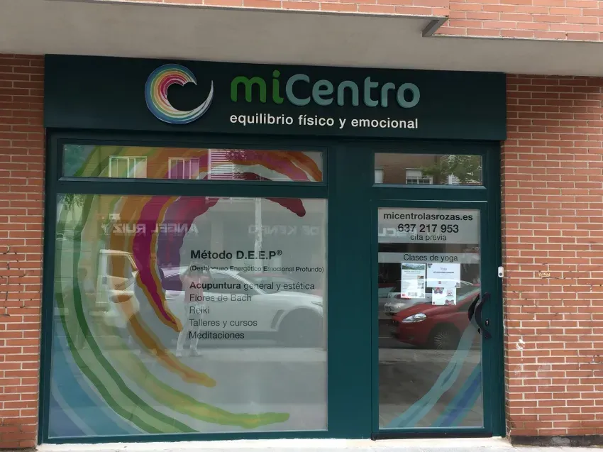 Fachada de la clínica “miCentro”, con un letrero verde y una entrada de cristal en un edificio de ladrillo.