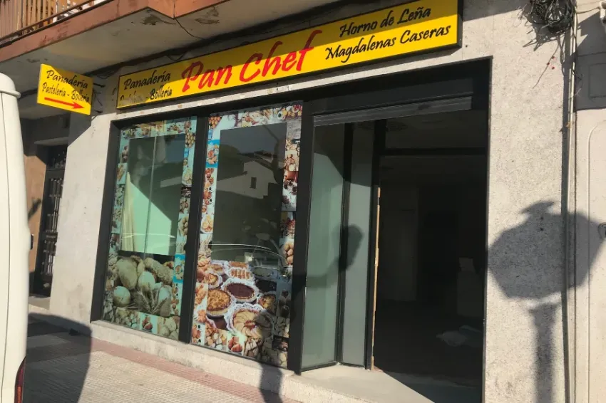 Escaparate de la panadería Pan Cher con un letrero amarillo, vitrinas de cristal y la puerta abierta en una calle soleada