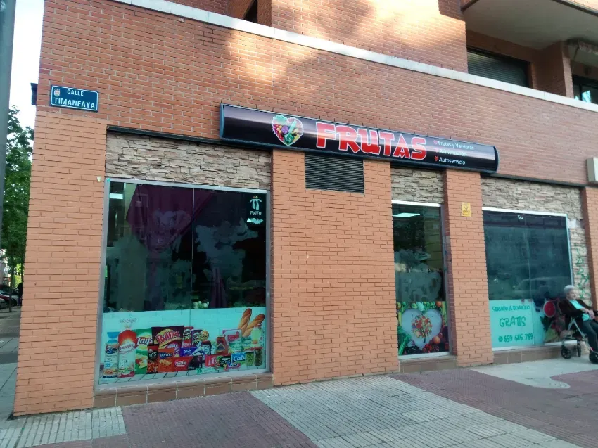 Local con fachada de ladrillo, grandes escaparates y un letrero oscuro sobre la entrada, en una acera de la ciudad