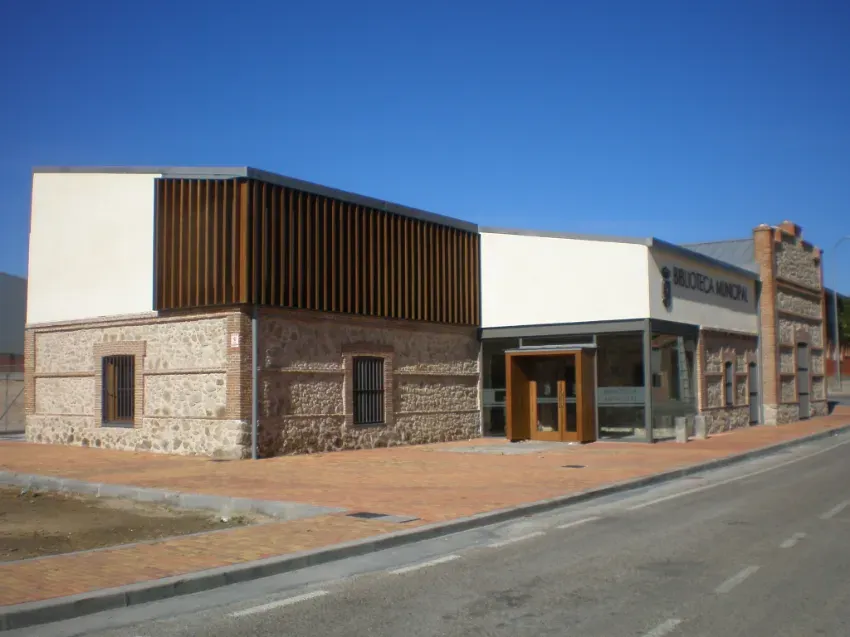 Edificio comercial moderno de piedra y cristal en una calle tranquila bajo un cielo azul despejado