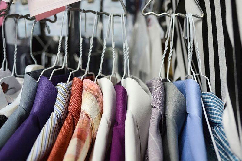 Un montón de camisas y corbatas cuelgan en un perchero.