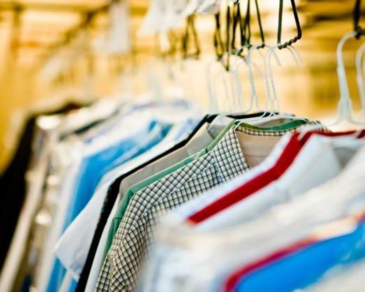Una fila de camisas colgadas en un perchero en una tienda.