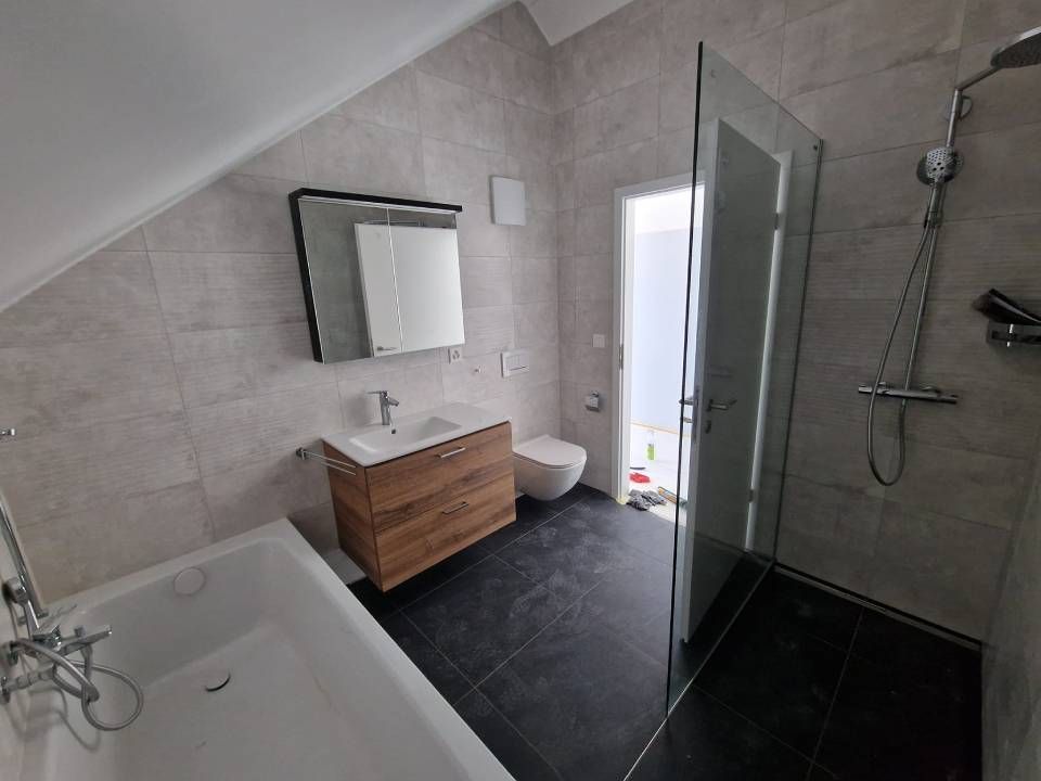 Une salle de bain avec douche à l'italienne, lavabo, WC et baignoire.