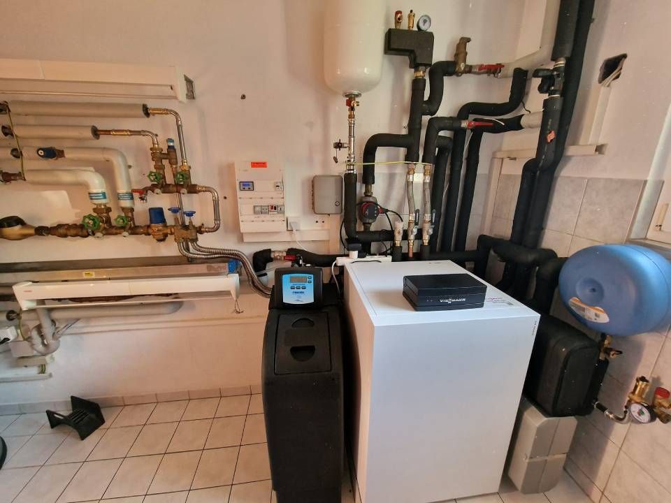 Une pièce avec beaucoup de tuyaux et un chauffe-eau