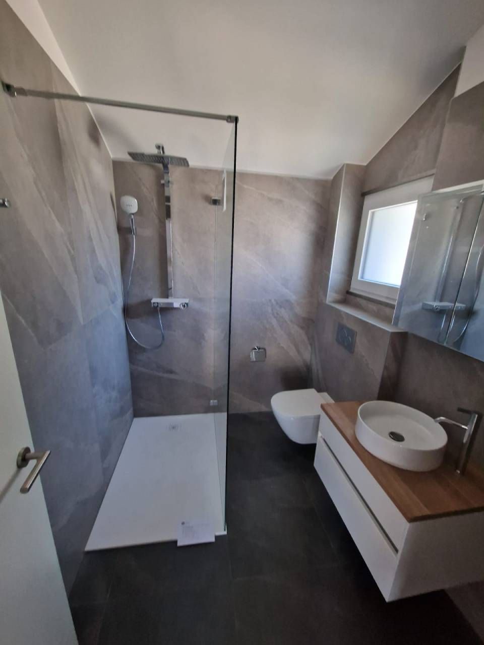 Une salle de bain avec une douche à l'italienne un WC et un lavabo