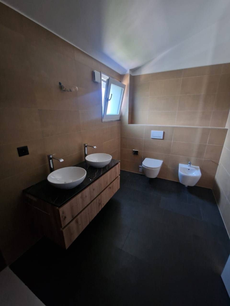 Une salle de bain avec deux lavabos et deux toilettes