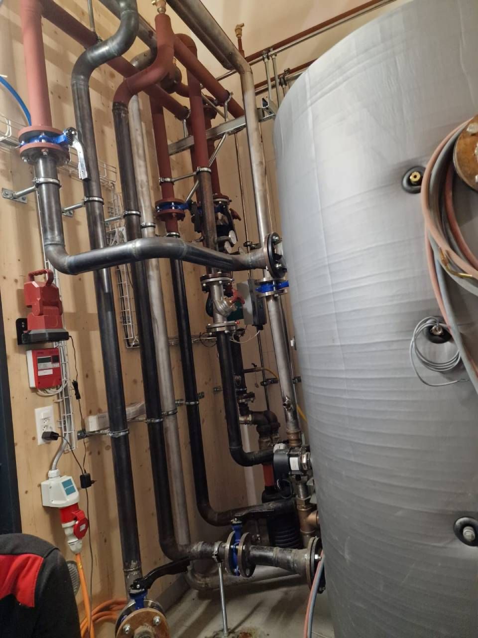 Une pièce remplie de nombreux tuyaux et vannes