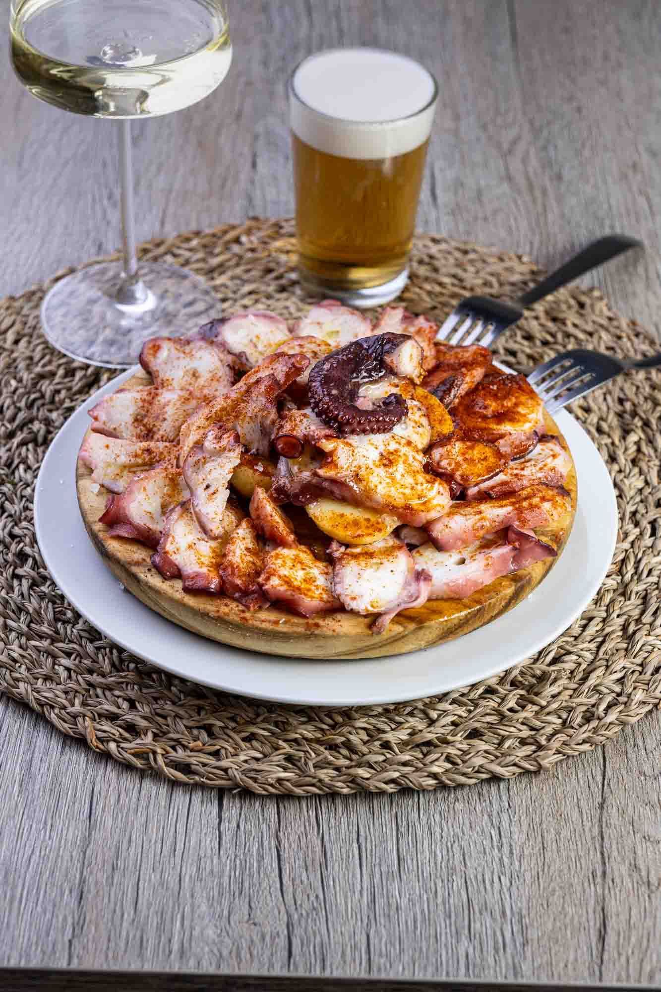 Un plato de comida y un vaso de cerveza en una mesa.