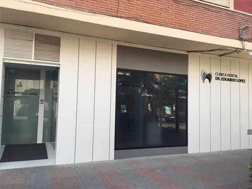 Un edificio blanco con un edificio de ladrillo detrás.