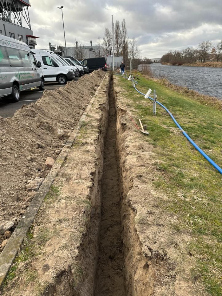 Ein schmaler Graben, der neben einer Reihe von Lieferwagen und einem Fluss in den Boden gegraben wurde.