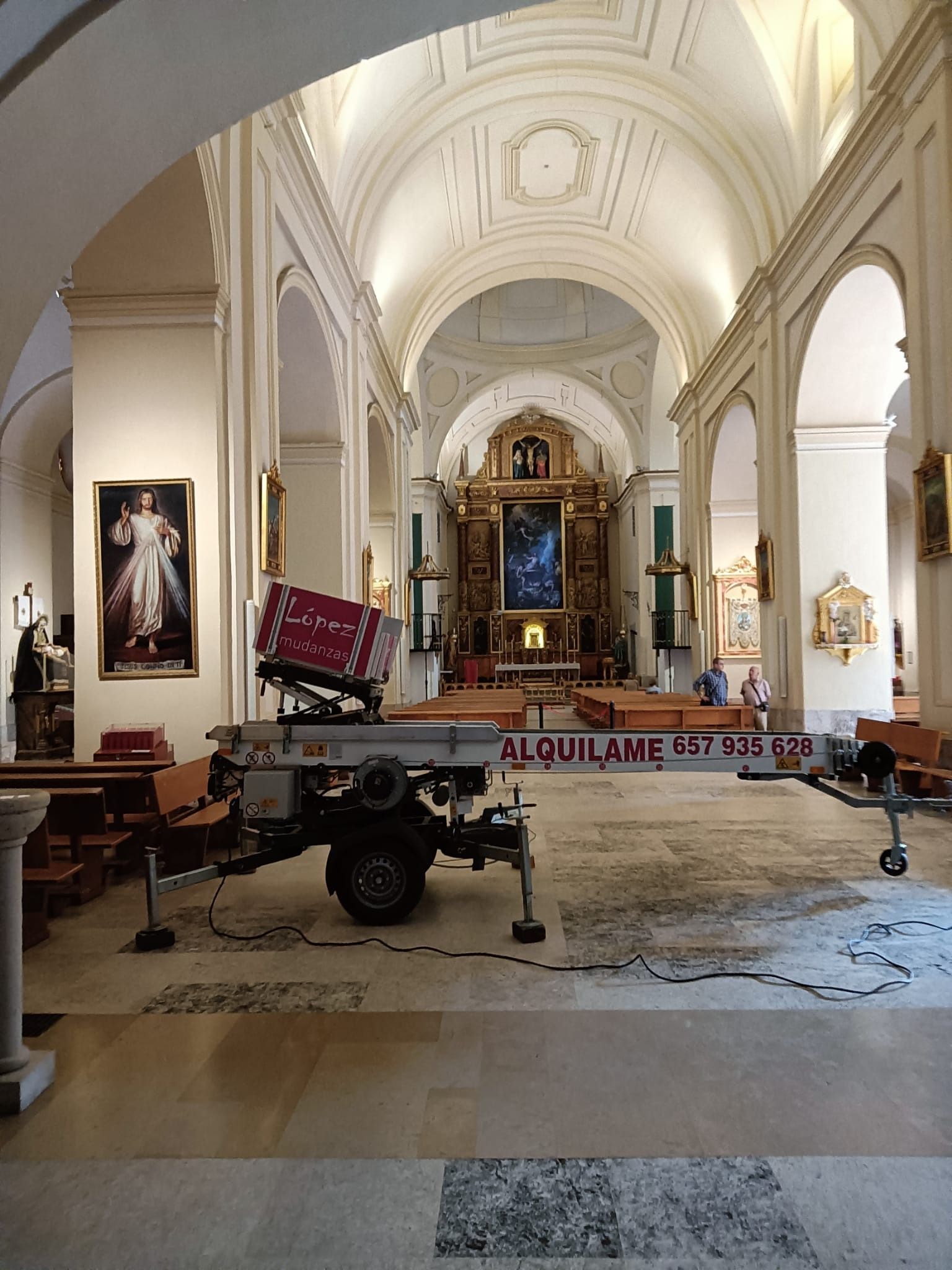 Vista del interior de la iglesia; un generador con ruedas se encuentra en el suelo frente al altar.