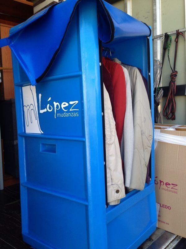 Taquilla azul con ropa colgada en su interior, bajo un toldo azul; logo