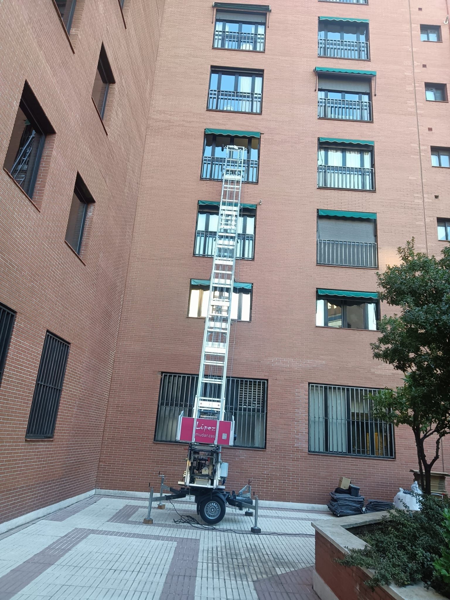 Un ascensor exterior alto se extiende hasta un edificio. Probablemente, el ascensor se utiliza para subir objetos a las ventanas.