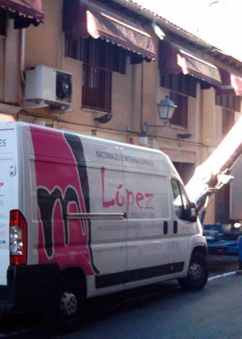 Una furgoneta blanca con el logo rosa y negro de