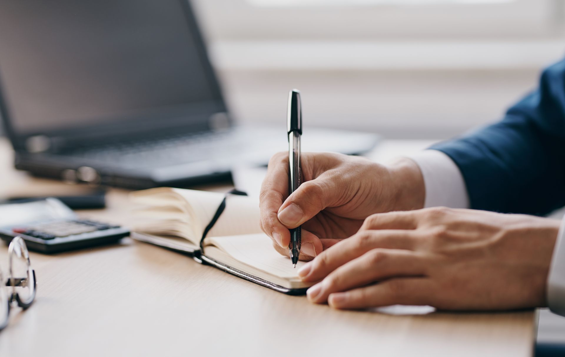 Un homme prend des notes devant un ordinateur