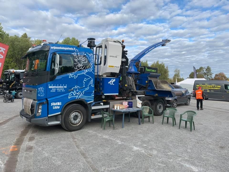 Sininen kuorma-auto on pysäköity parkkipaikalle.