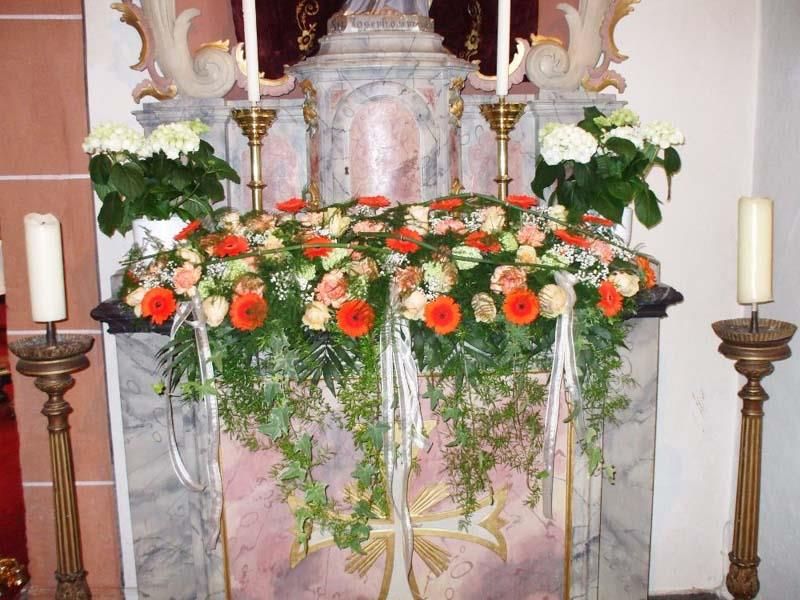 Ein mit Blumen und Kerzen geschmückter Kirchenaltar