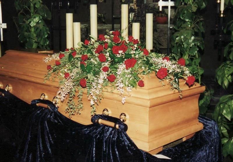 Ein Holzsarg mit Blumen und Kerzen darauf