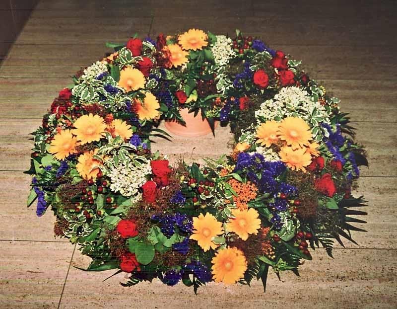 Ein Blumenkranz liegt auf einem gefliesten Boden