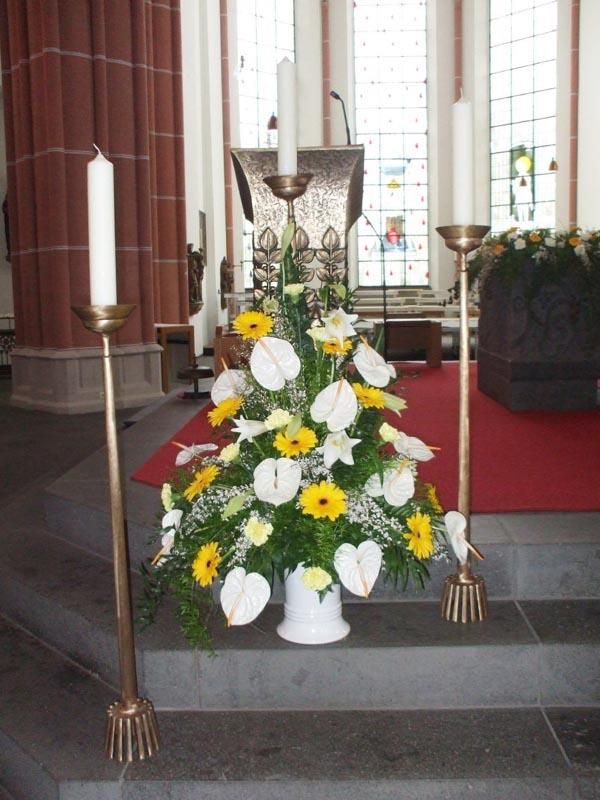Ein Kirchenaltar mit Blumen und Kerzen darauf