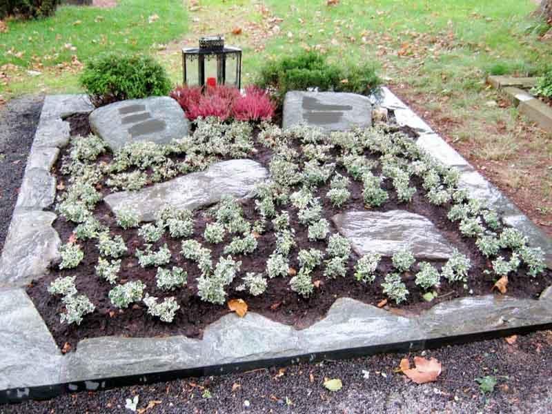 Ein Friedhof mit Blumen und Steinen und einer Laterne