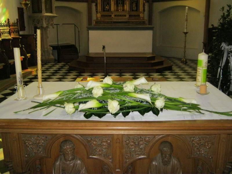 Ein Kirchenaltar mit Blumen und Kerzen darauf
