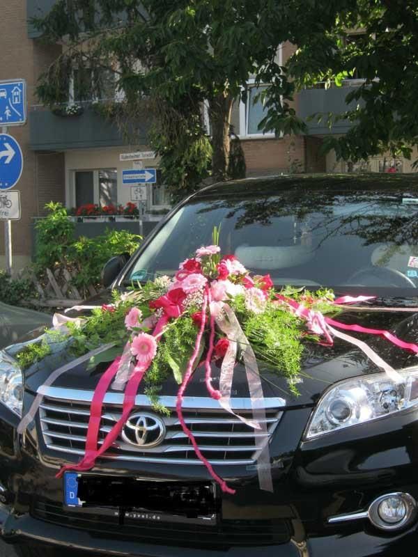 Ein schwarzes Toyota-Auto, geschmückt mit Blumen und Bändern