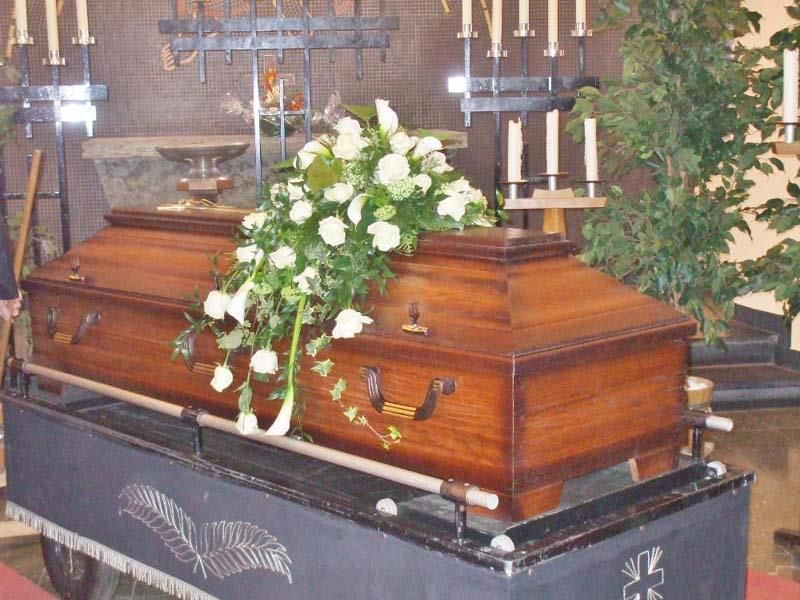 Ein Holzsarg mit weißen Blumen darauf