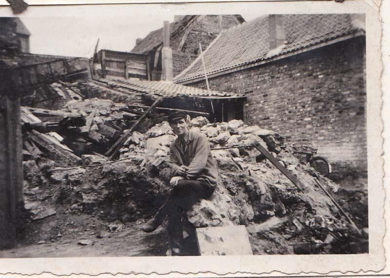 Ein Schwarzweißfoto eines Mannes, der auf einem Steinhaufen sitzt