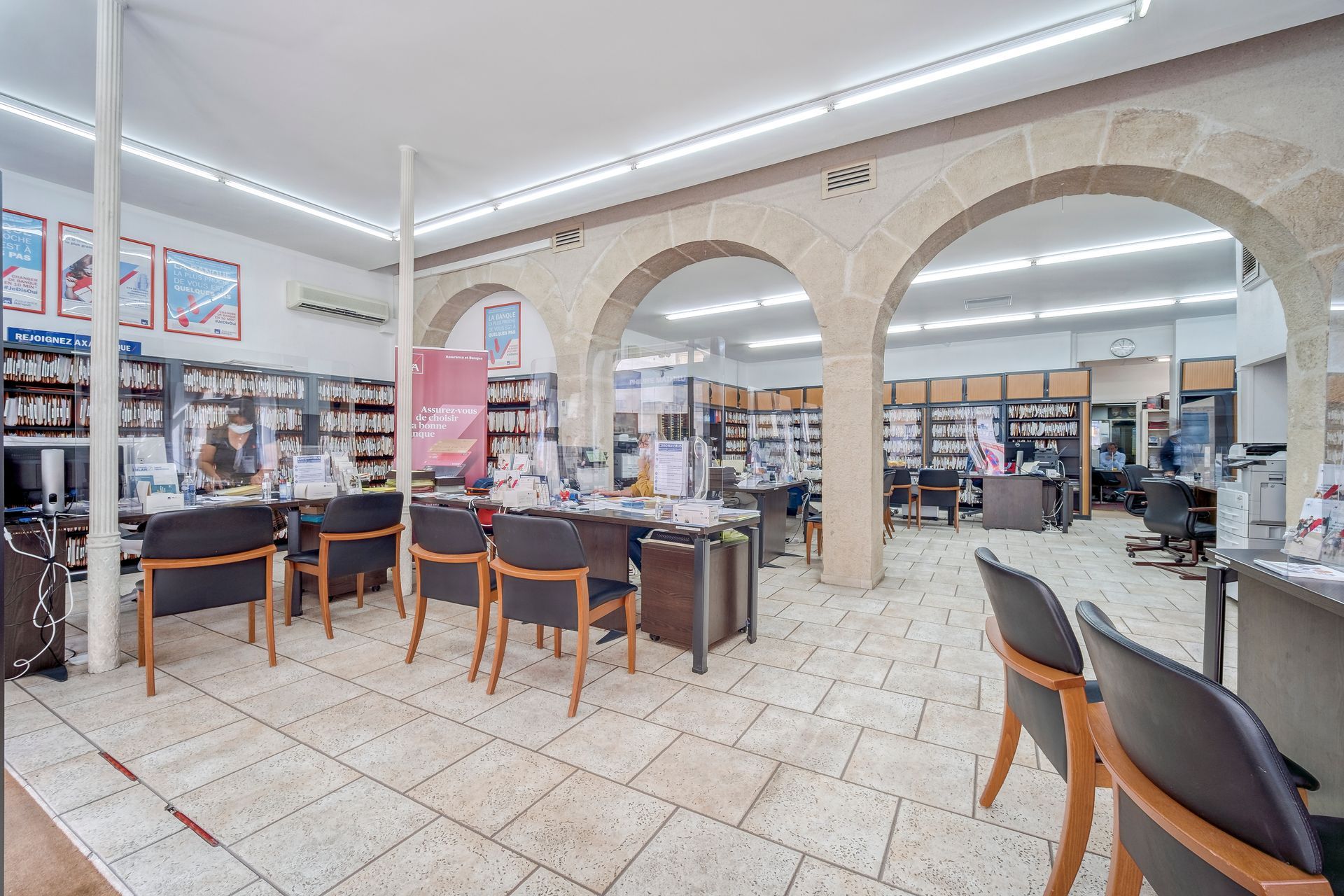 Intérieur de l'agence avec arches, colonnes, bureaux et sièges