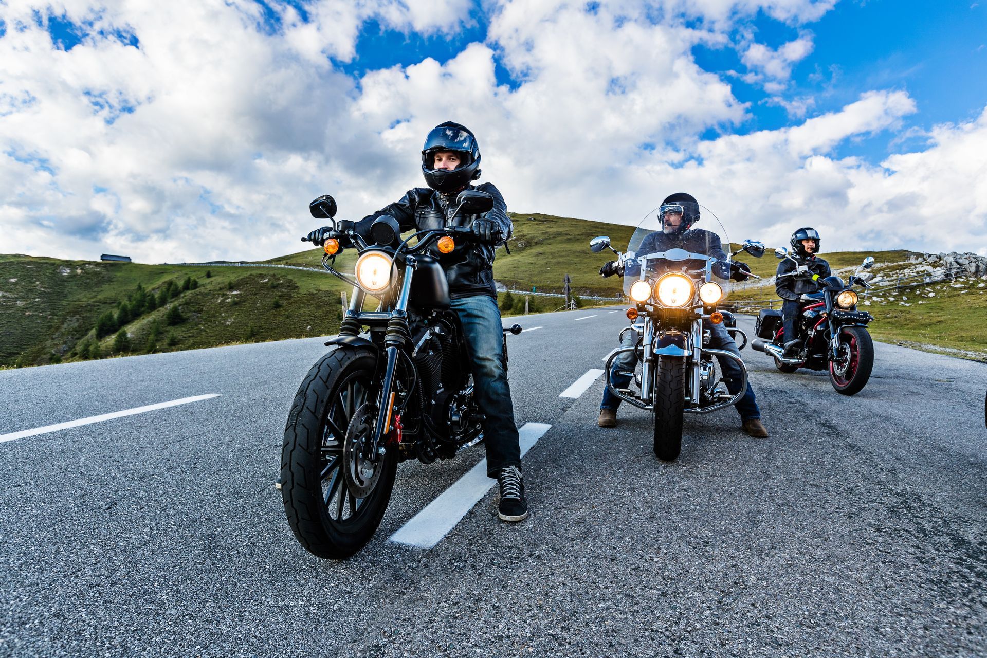 Trois motards arrêtés au milieu d'une route de campagne