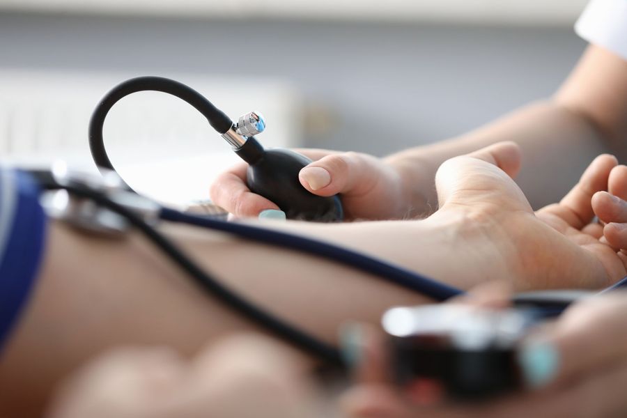 Une infirmière prend la tension artérielle d'un patient