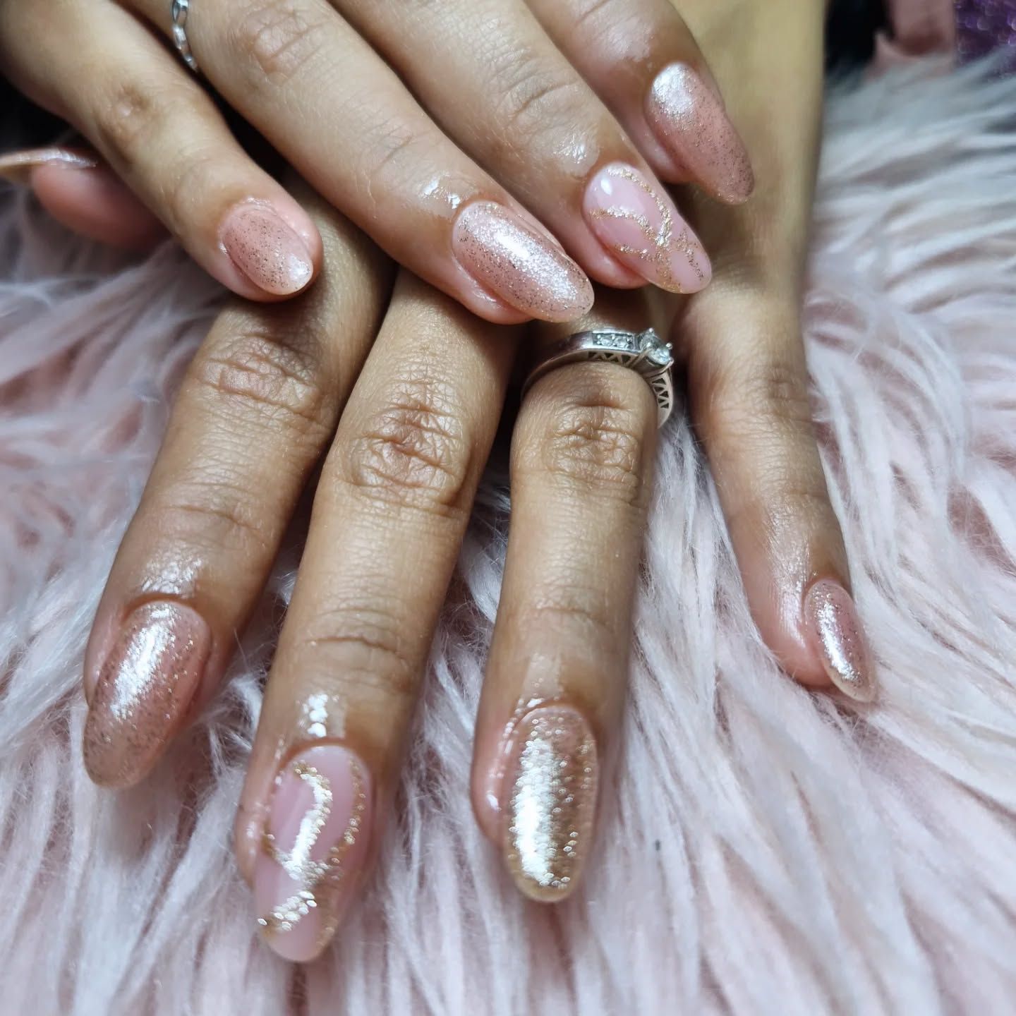 Manos con uñas arregladas de color rosa brillante sobre un fondo de pelo rosa suave