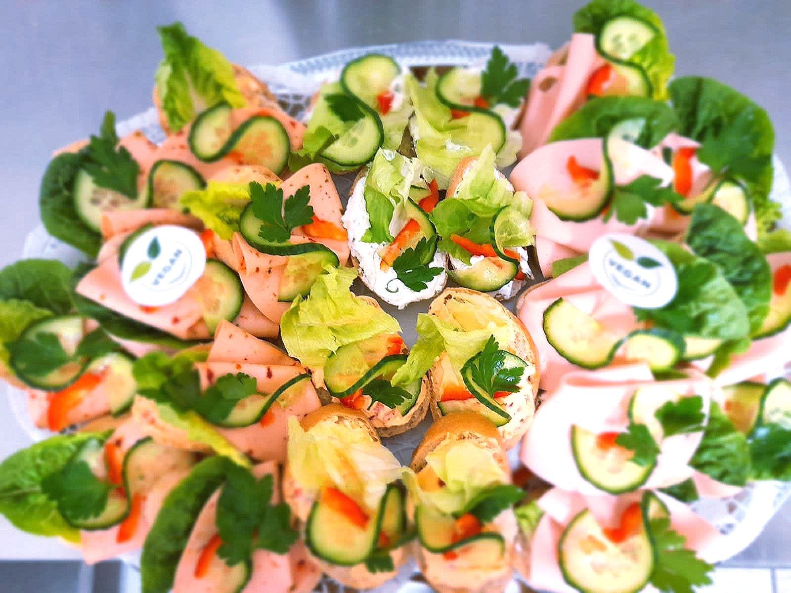 Ein Teller mit Essen mit Salat und Gurken darauf