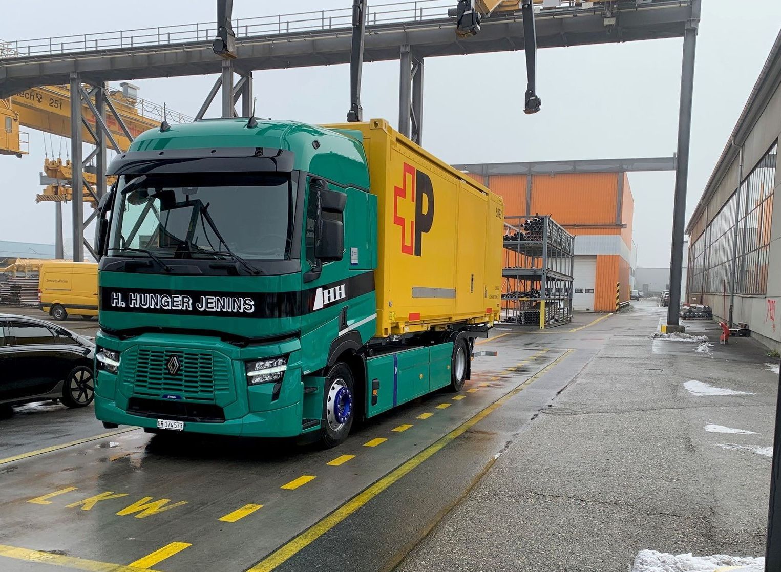 Ein grün-gelber LKW steht auf einem Parkplatz.