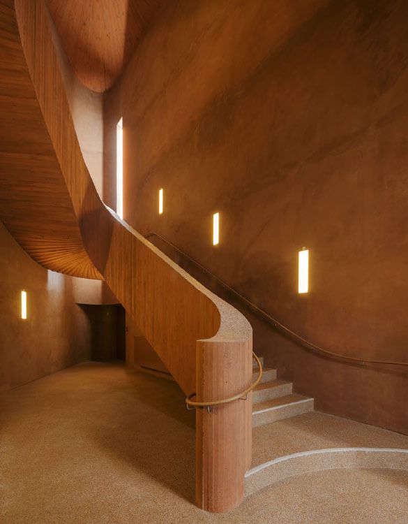 Museum Küppersmühle. A wooden spiral staircase in a building with lights on the wall