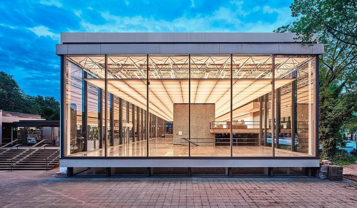 Lehmbruck Museum. A large building with a lot of windows and trees in the background.