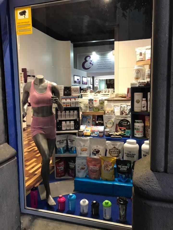 Un maniquí está parado frente al escaparate de una tienda.