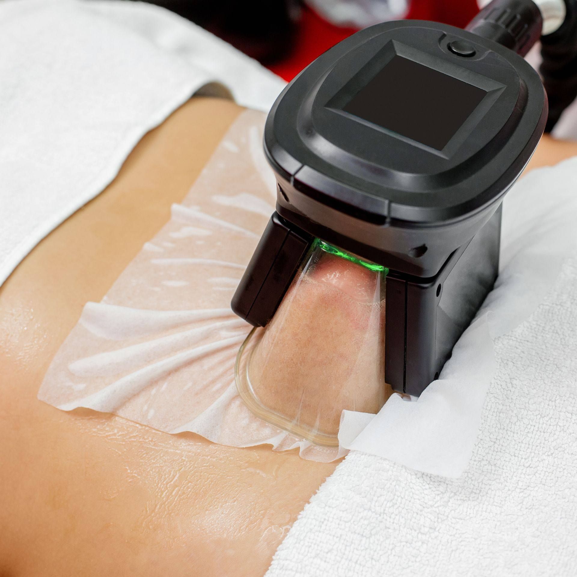 Una mujer está acostada en una cama con una máquina sobre su estómago.