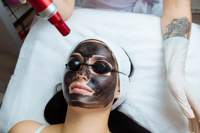 Una mujer se pone una máscara negra en la cara.