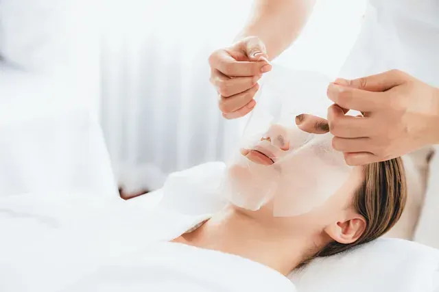 Una mujer está recibiendo un tratamiento facial en un spa.