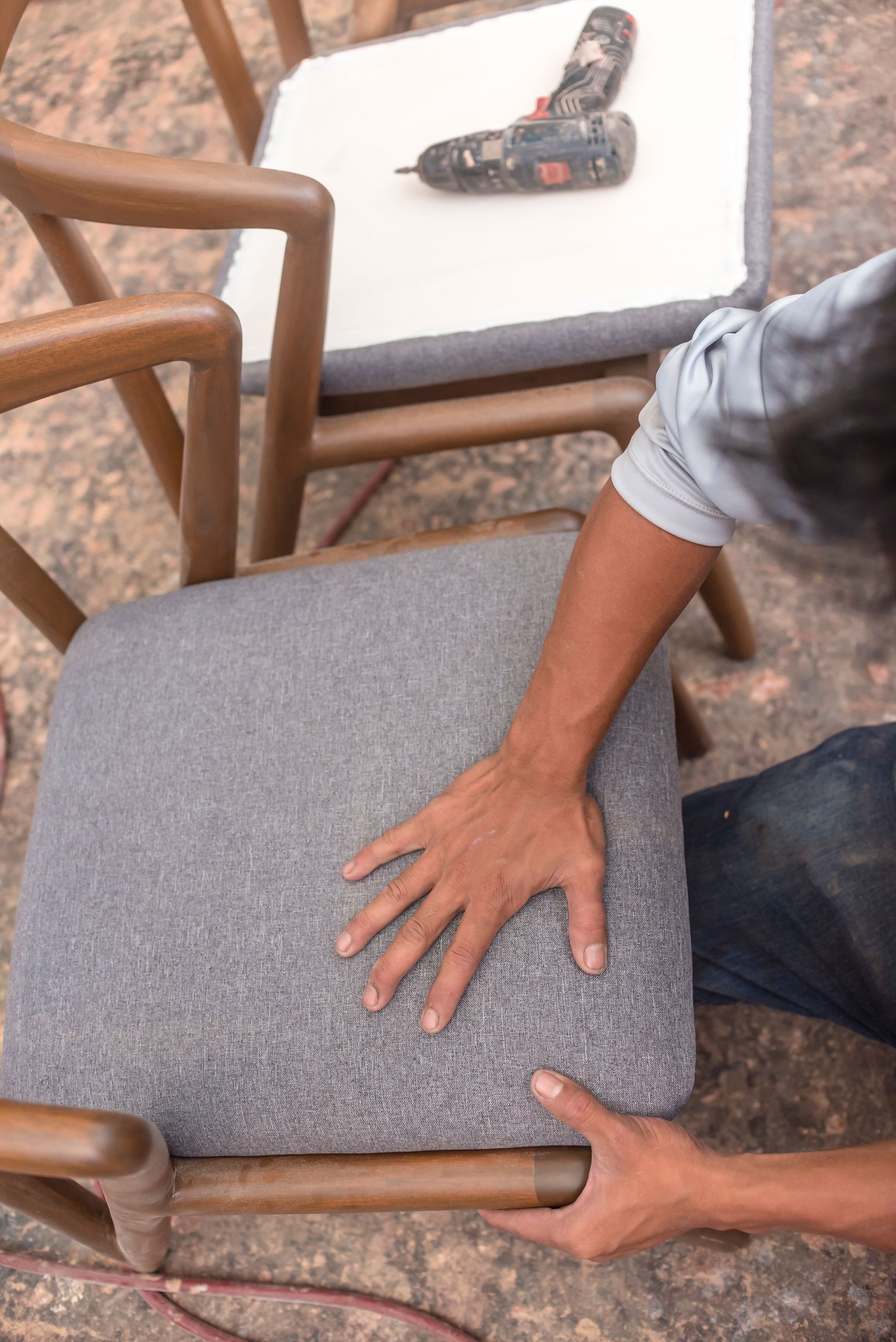 Un homme travaillant le tissu d'une chaise moderne