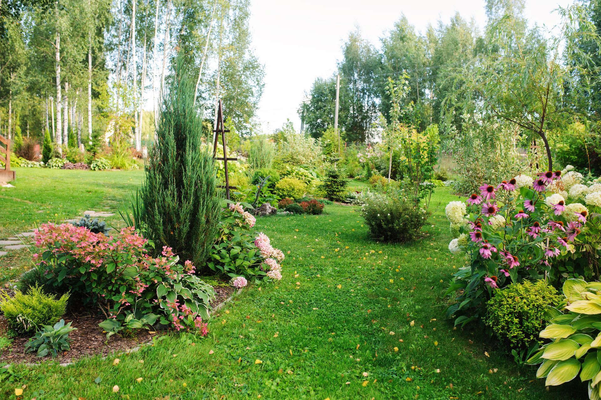 Jardin aménagé avec des arbres, buissons et fleurs