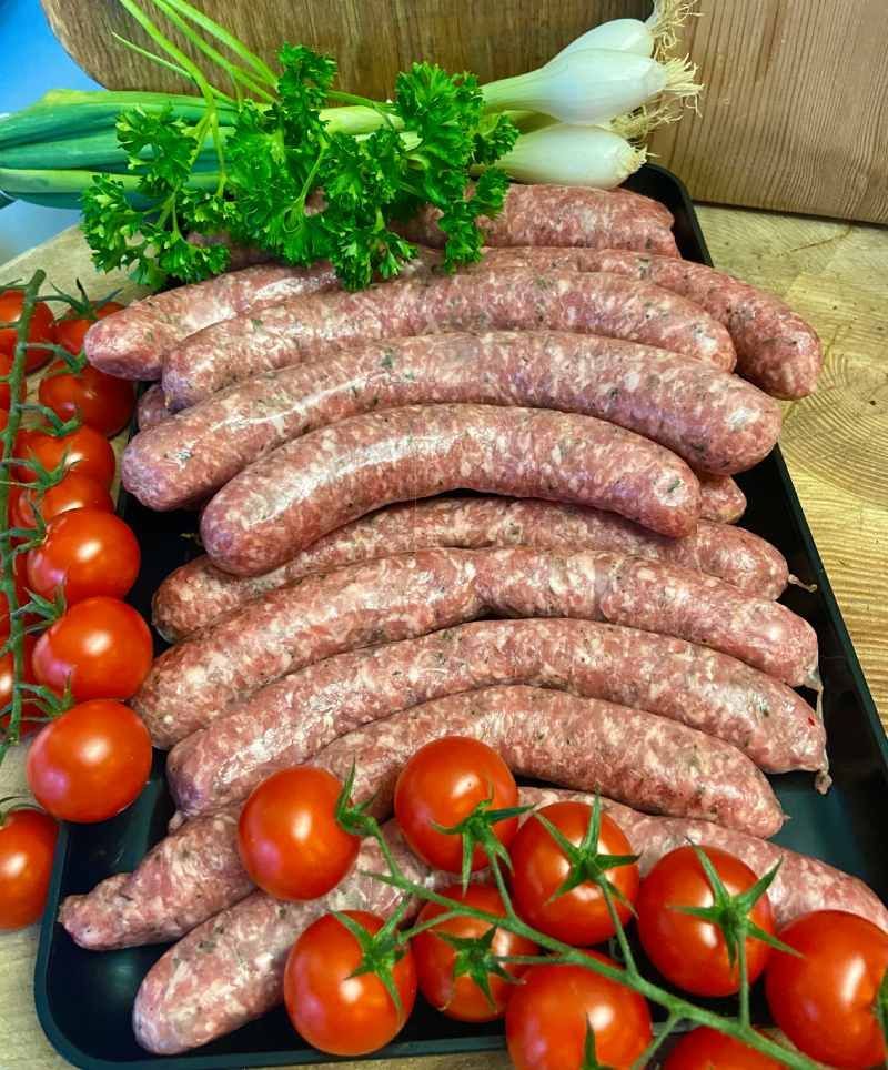 Un plateau de saucisses et de tomates sur une table.