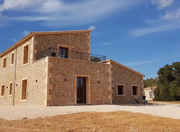 Una gran casa de piedra con un balcón en la parte superior.