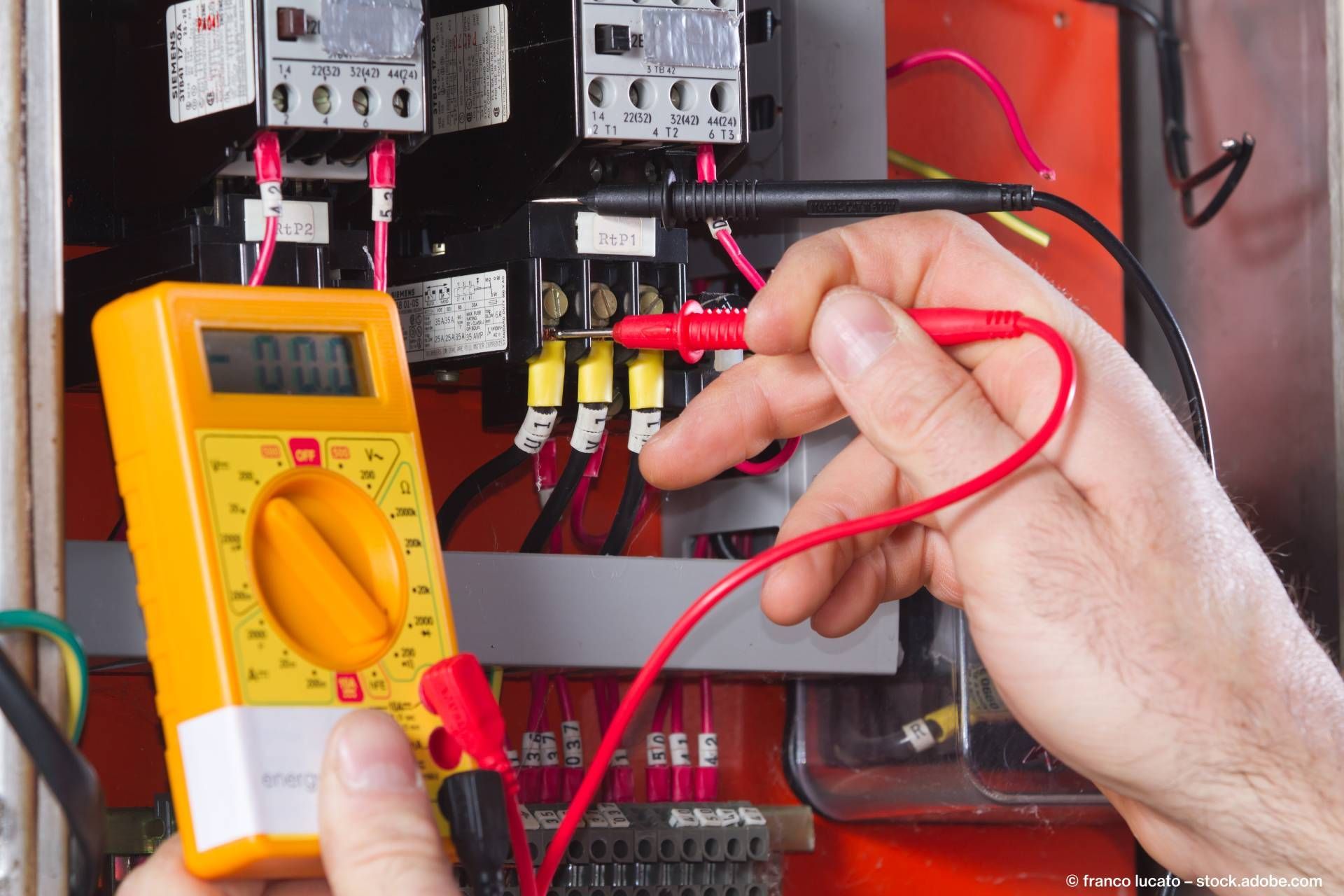 Elektriker prüft Leitungen mit einem Strommesser