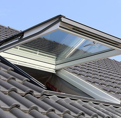 Velux ouvert sur une toiture foncée