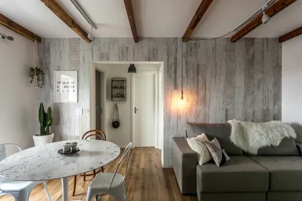 Dentro de una tienda de zapatos, un trabajador limpia, rodeado de cajas de zapatos apiladas y expositores.